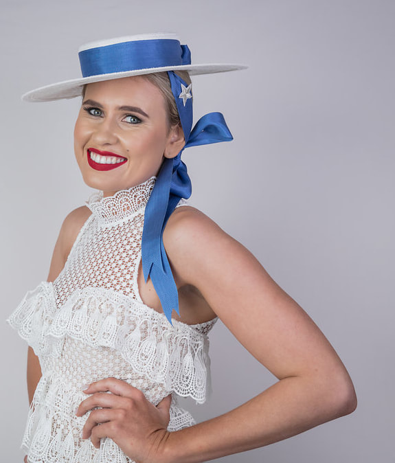 Mini hat made of white straw and a long beautiful blue satin ribbon that is the hat band and hangs to the side for a very feminine look