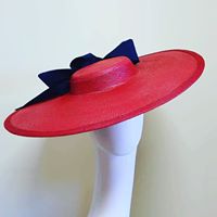 wide red brimmed hat with navy blue ribbon with bow designed by hats by zarbella