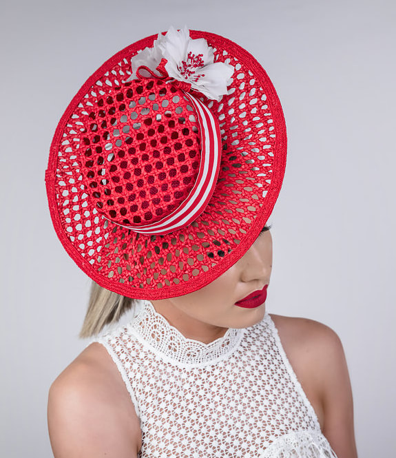 Bright red woven straw hat with pretty white feathers and a white and red hat band