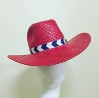 bright red straw cowgirl hat with blue and white ribbon band